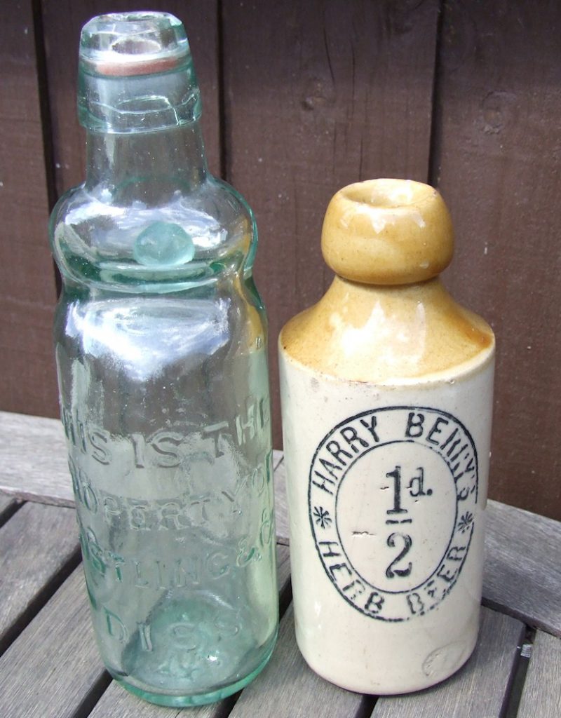 Picture of a glass codd bottle and a stone ginger beer bottle circa 1900.